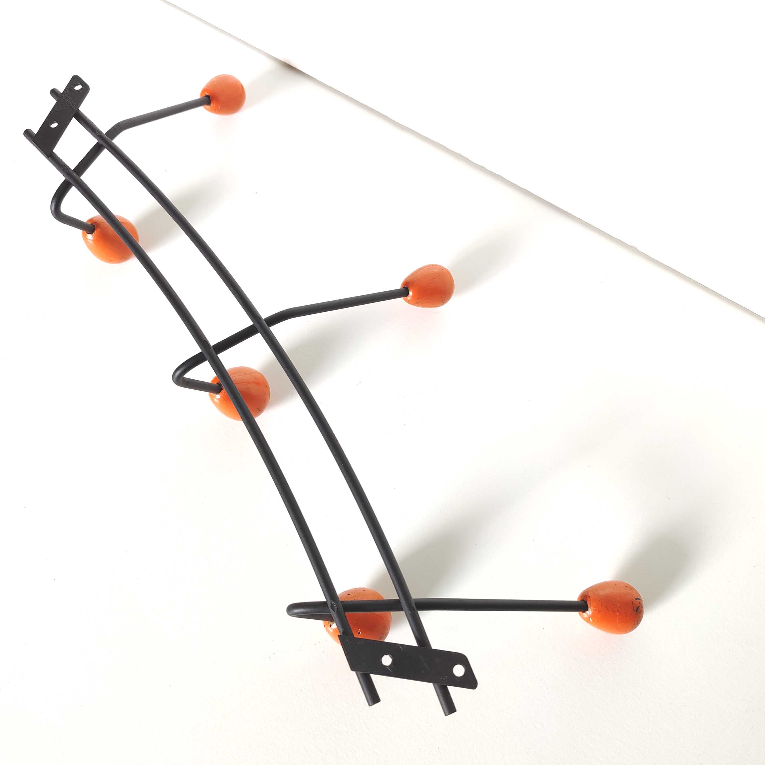Black metal coat rack and orange wood balls