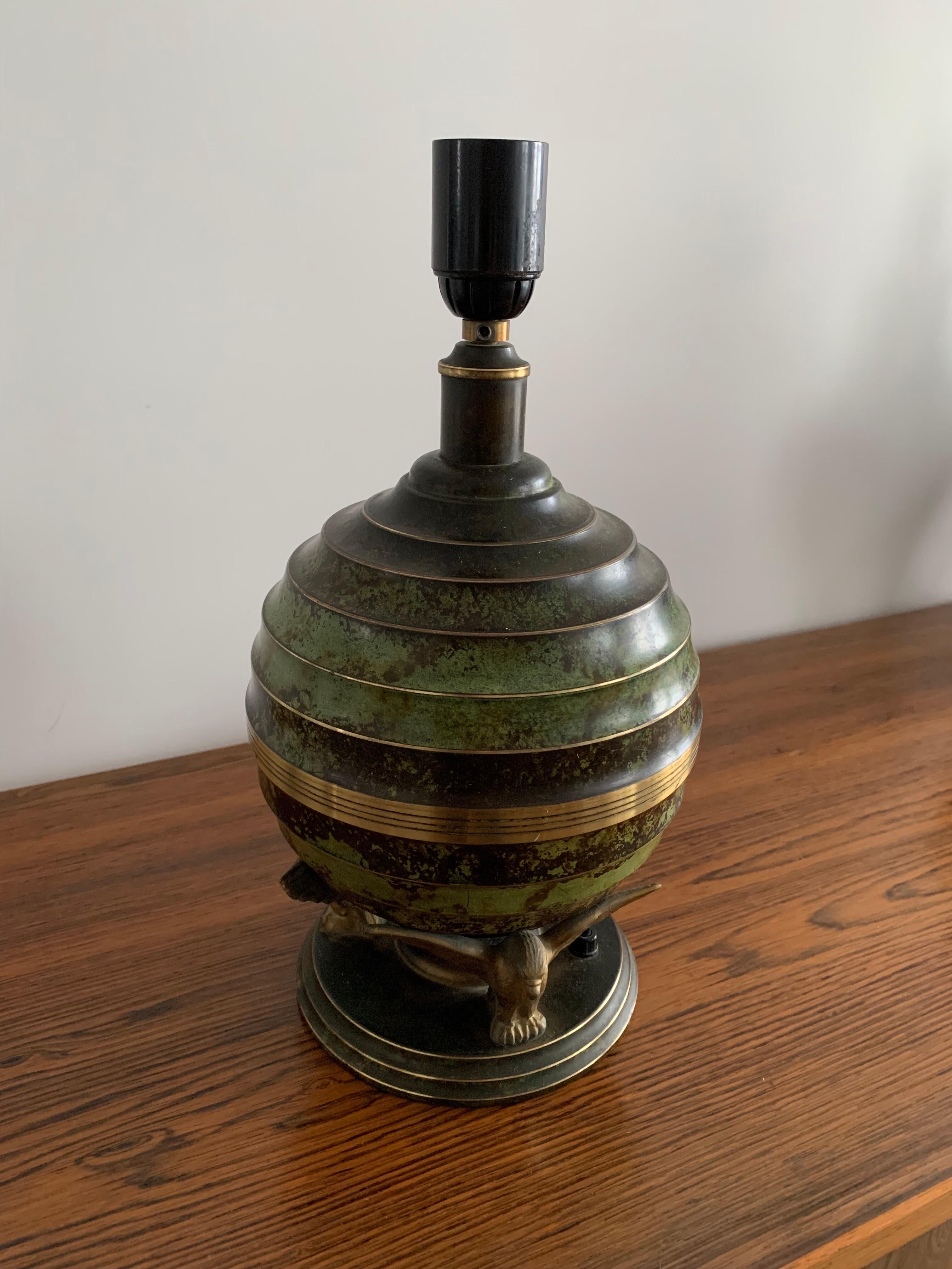 Art Deco table lamp in patinated bronze with eagles holding a globe, France 1940.