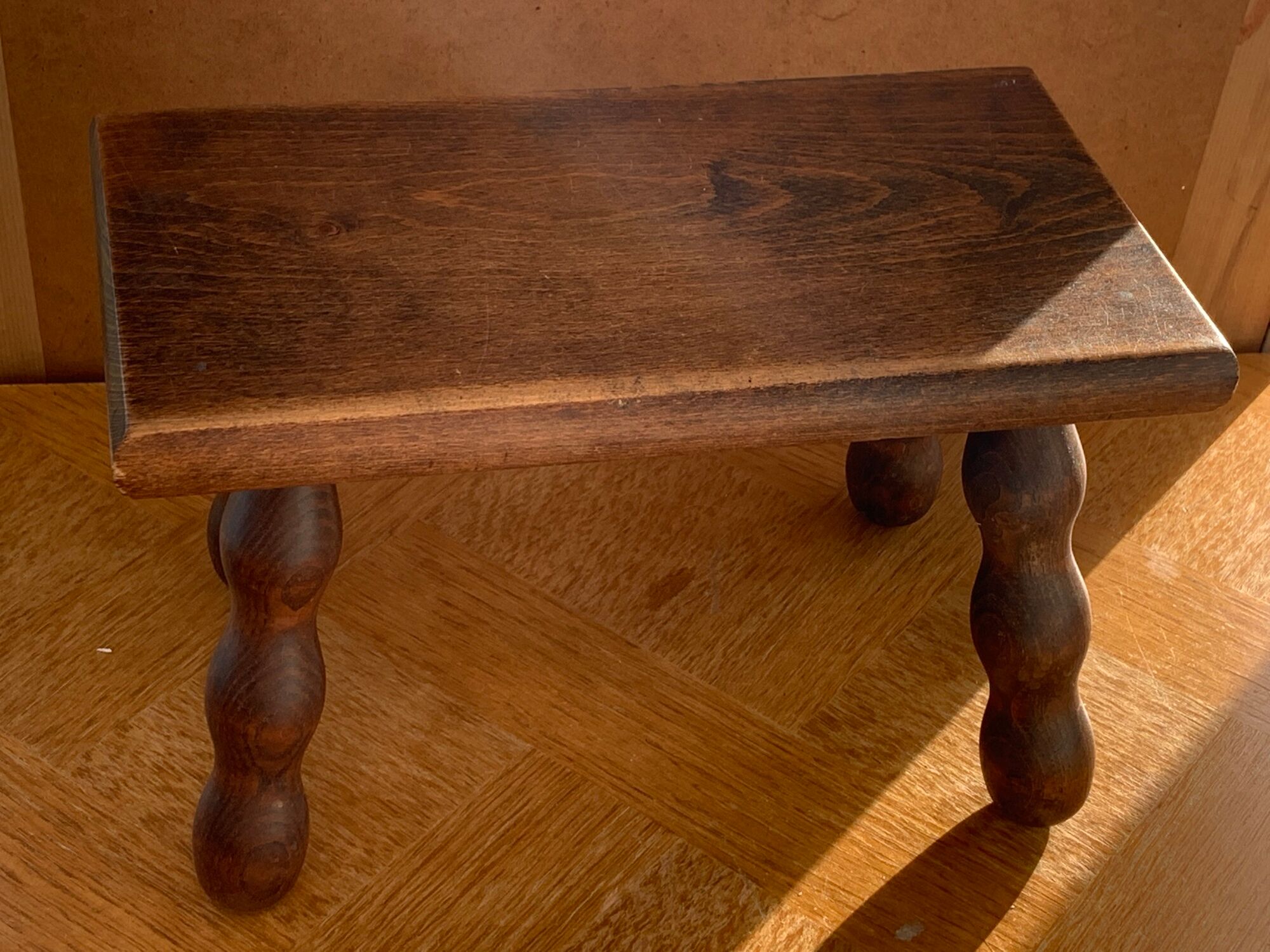 Footstool in varnished wood turns old