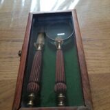 Magnifying glass and paper cutter in a vintage wooden box