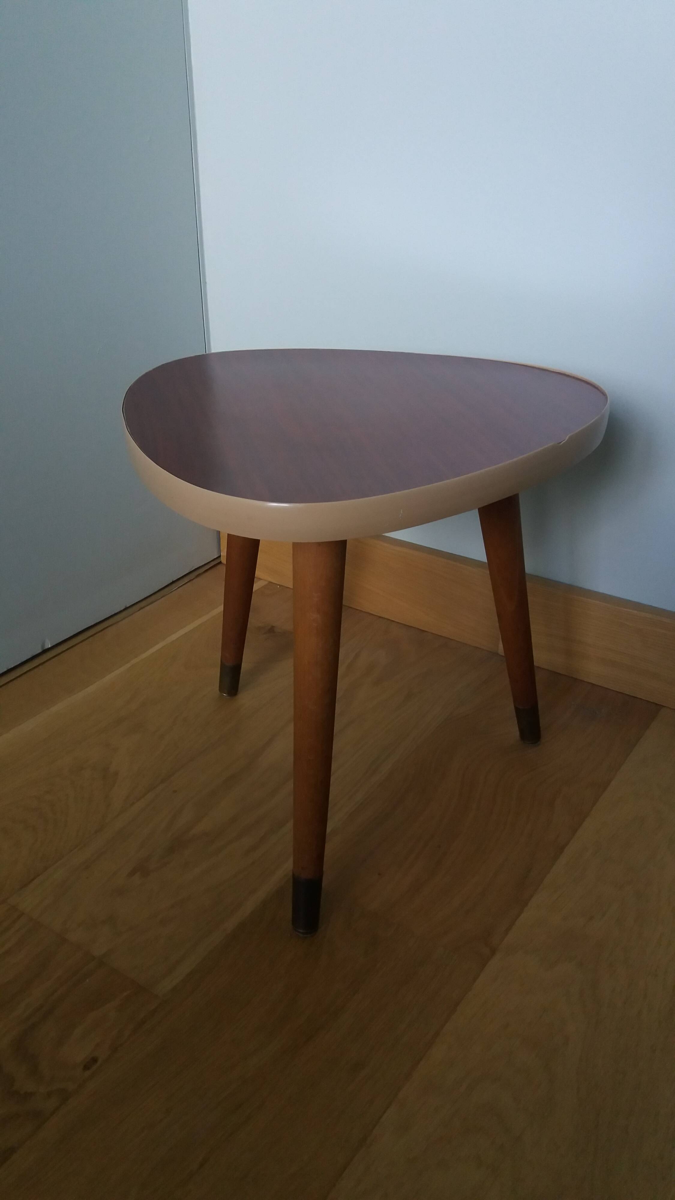 Tripod console table plant stand in the shape of a plectrum.