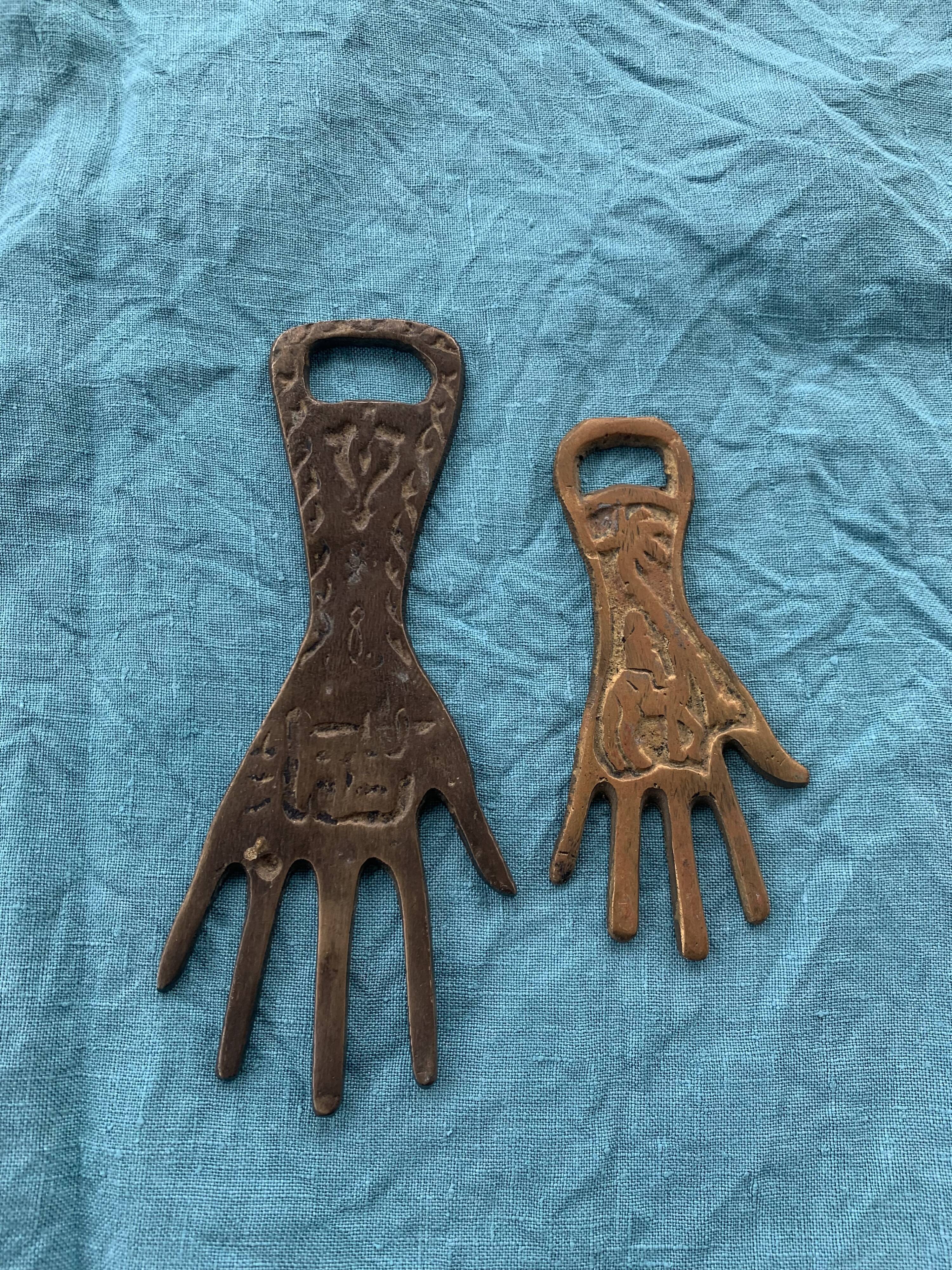 Two brass bottle openers in the shape of a chiseled hand vintage oriental décor