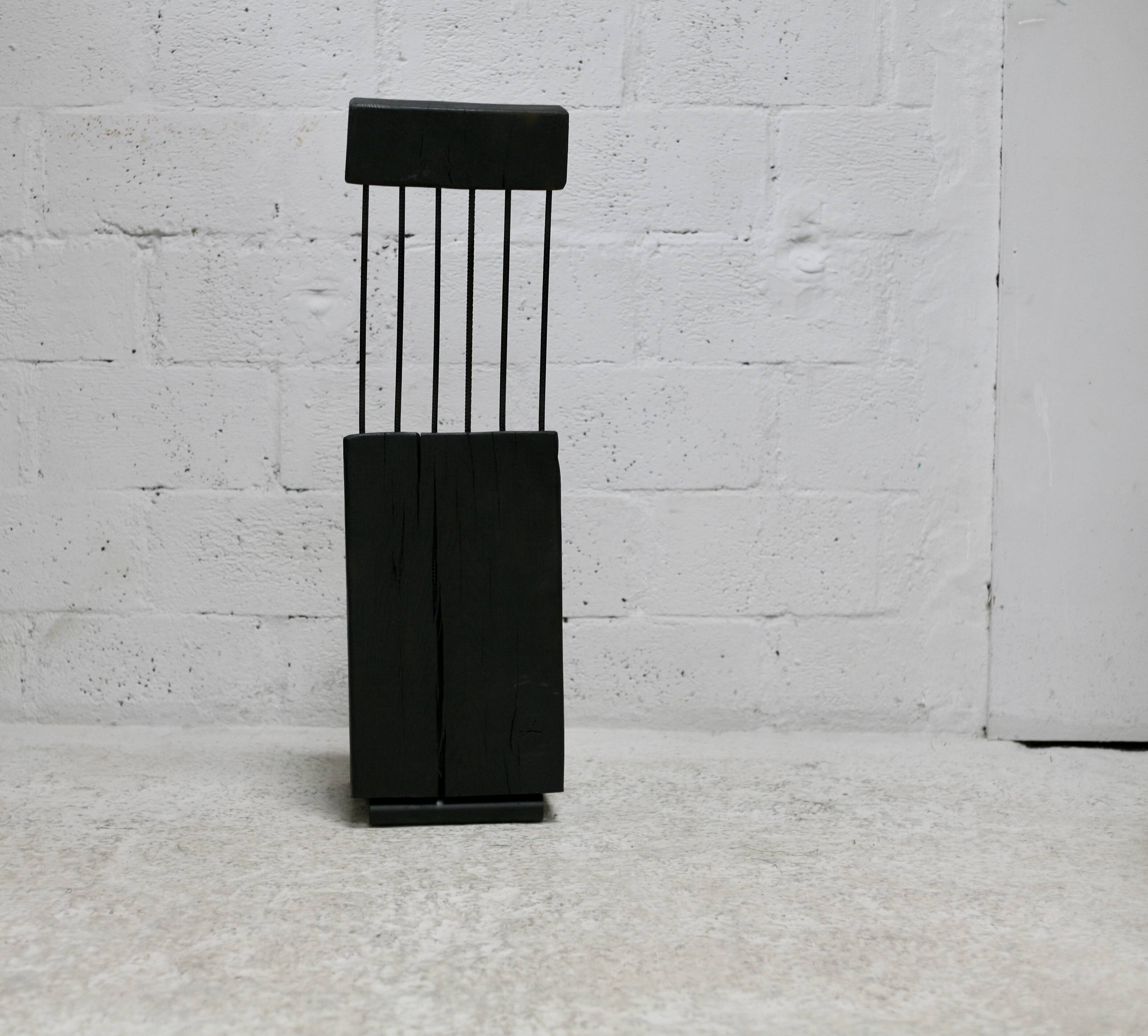 Brutalist chair, black-stained raw wood, steel. Work from the 1970s