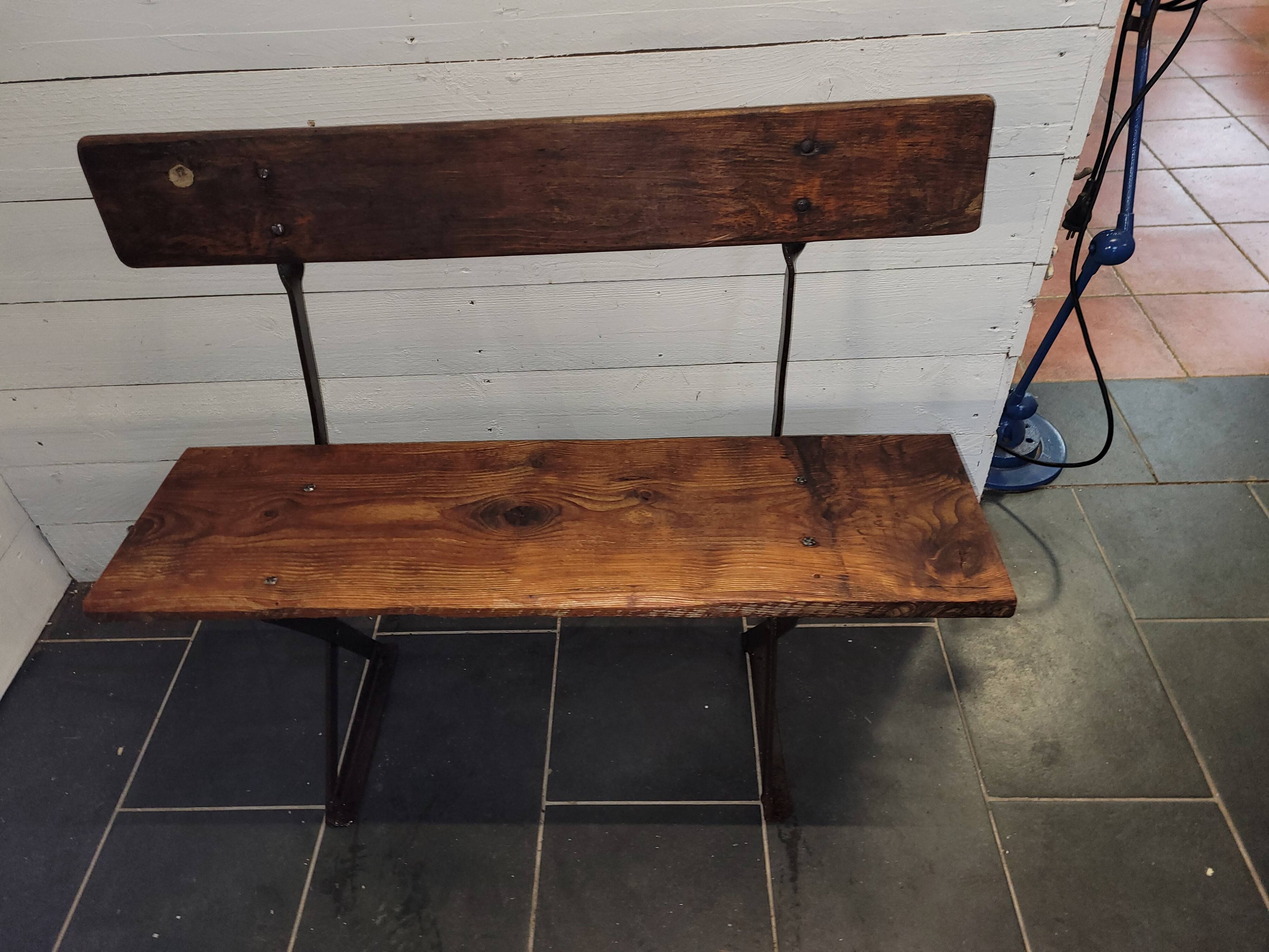 Old garden bench with iron legs and wooden seats