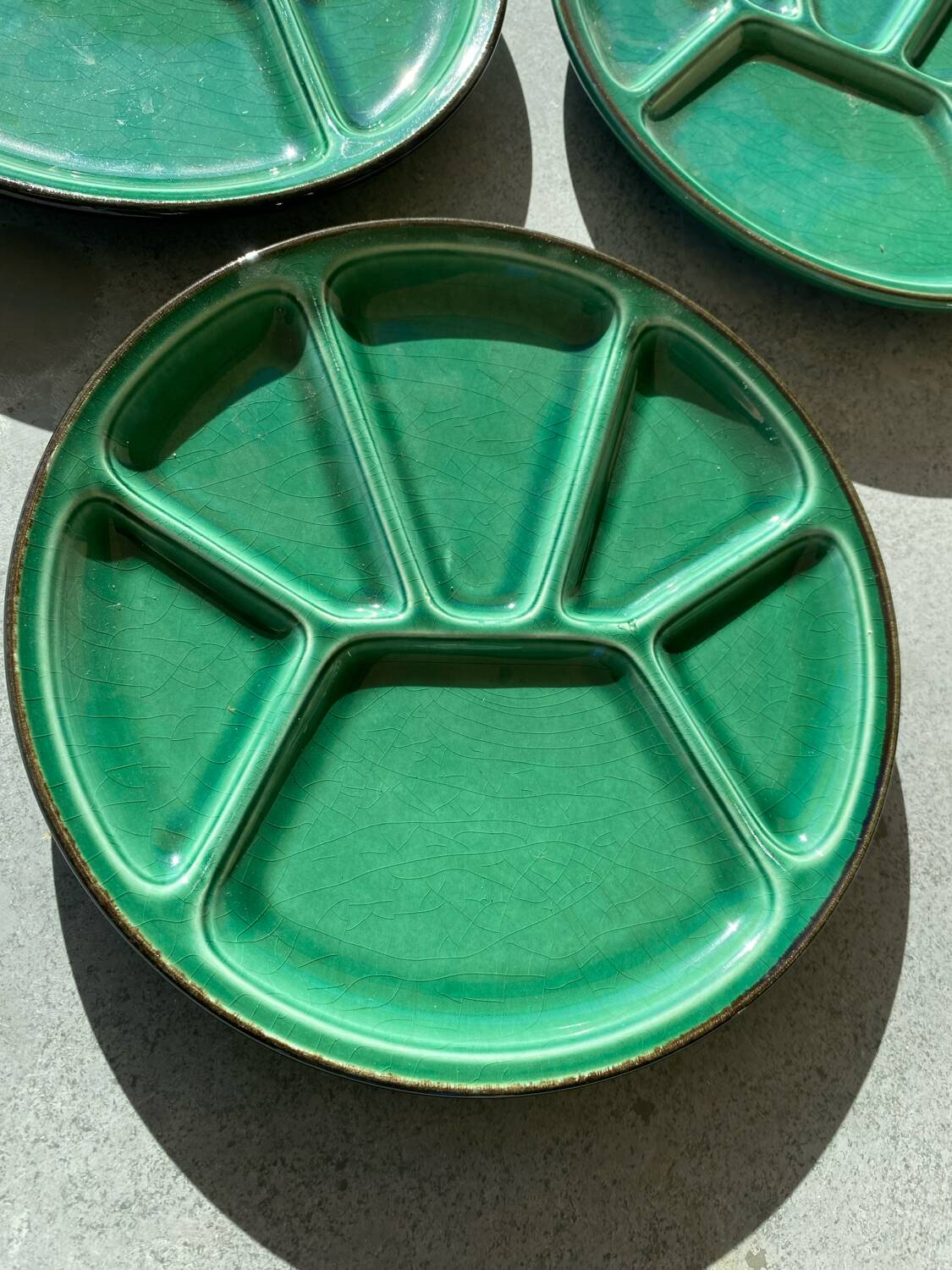 Many glazed stoneware plates with compartments.