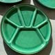Many glazed stoneware plates with compartments.