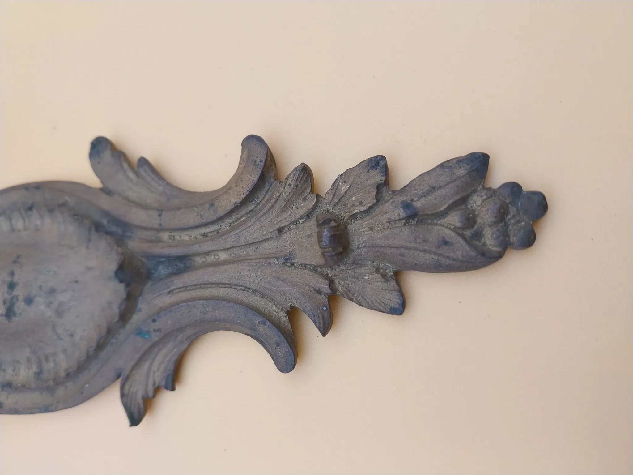 Pair of wall sconces in bronze candle holders with leaf medallion decoration.