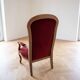 Louis XV style Voltaire armchair in wood and burgundy fabric.