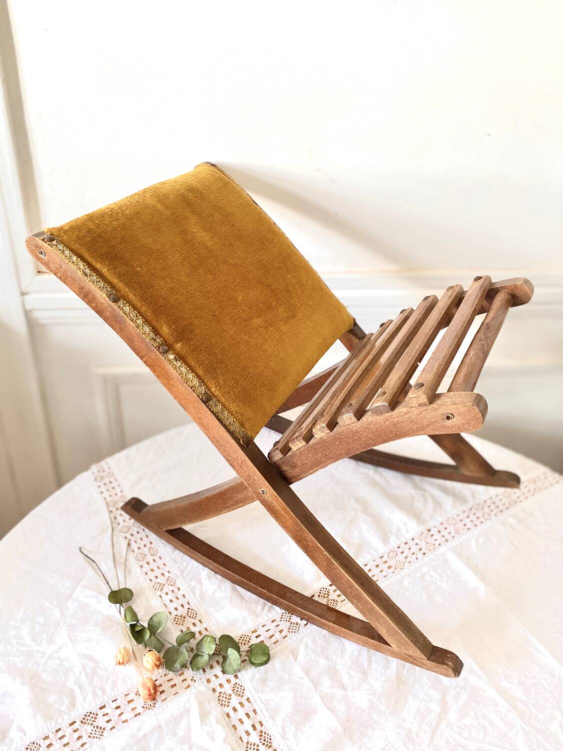Old wooden rocking footrest with velvet fabric