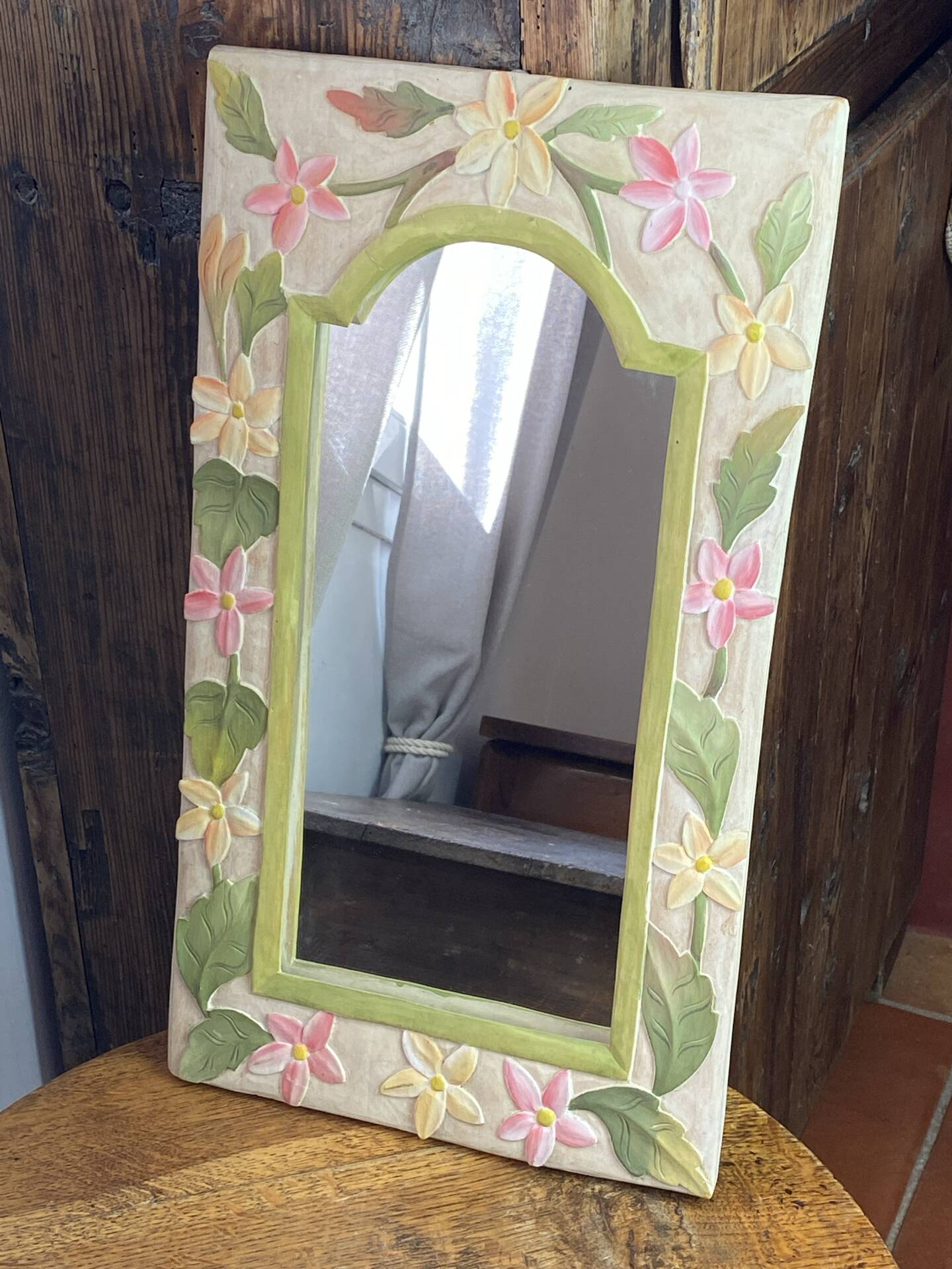 Carved wooden mirror, colourful floral decoration.