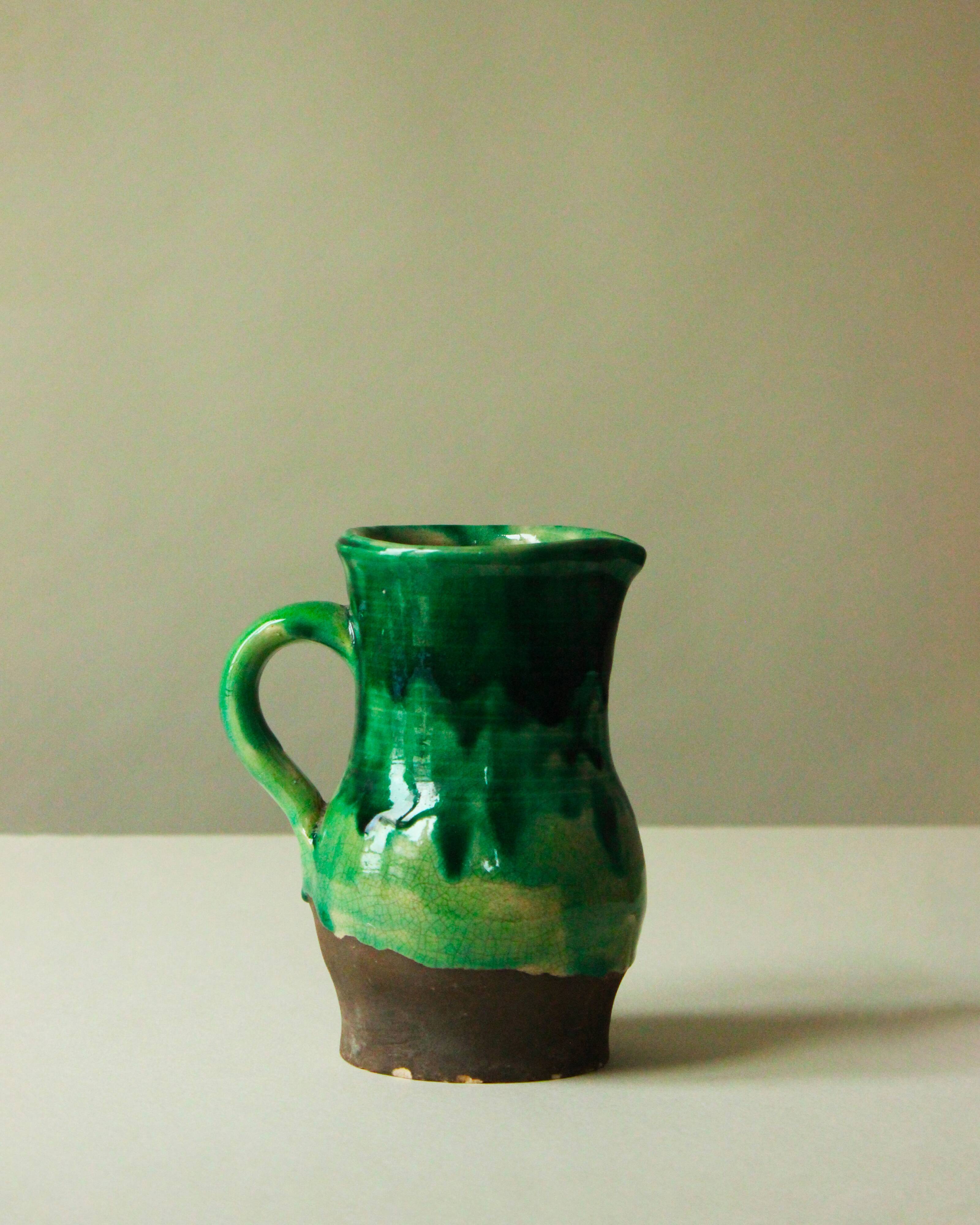 Glazed ceramic pitcher in green and brown by the potter Pierre Roulot.