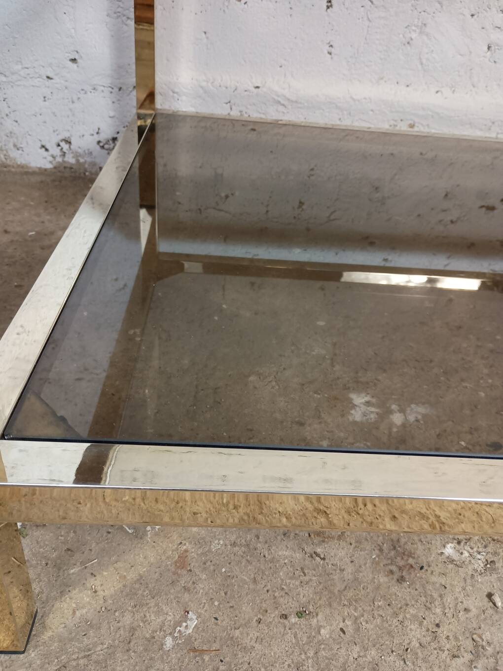 1970s coffee table in brass with a double smoked glass top.