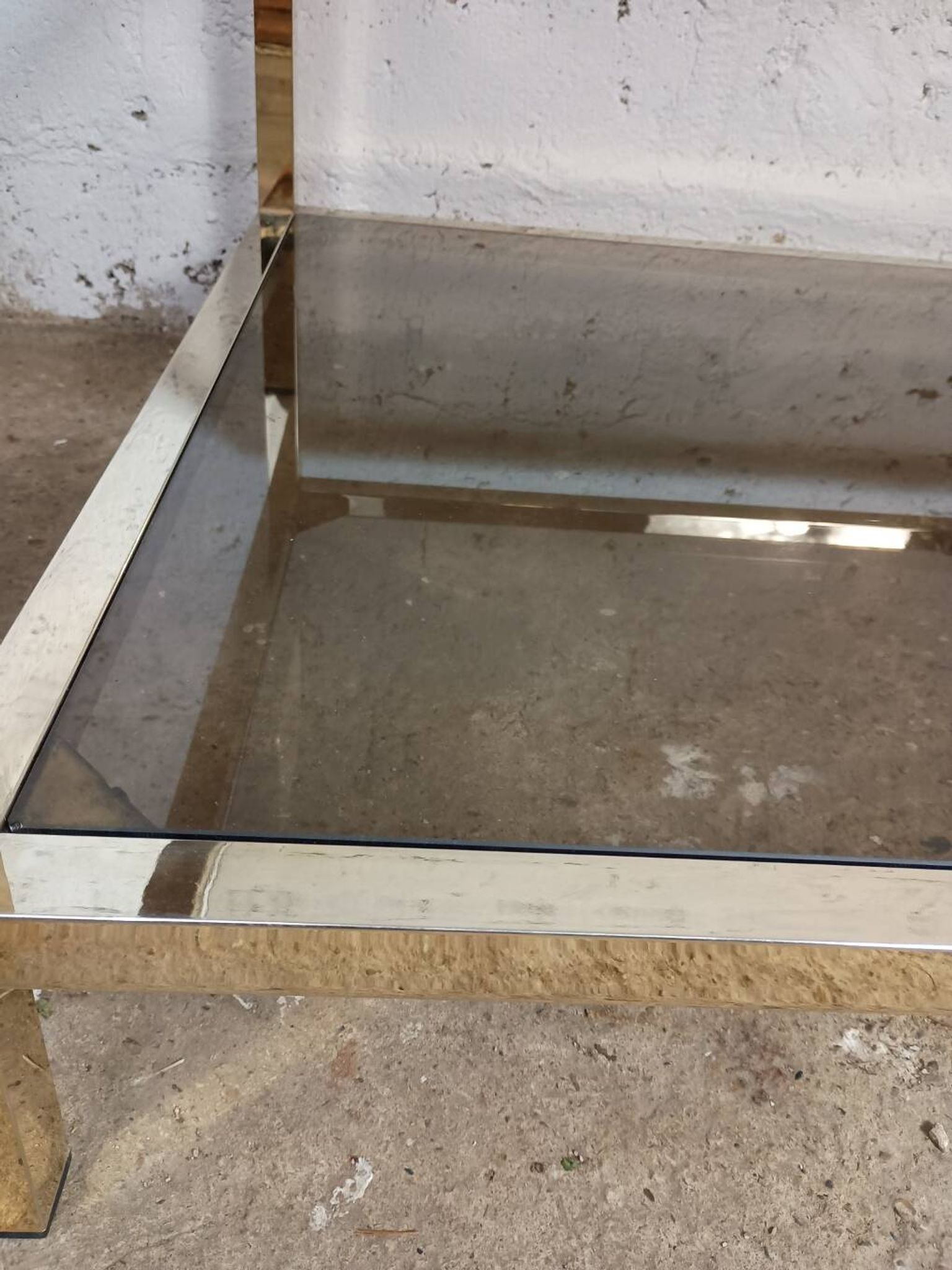 1970s coffee table in brass with a double smoked glass top.