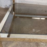 1970s coffee table in brass with a double smoked glass top.