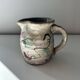 Floral decorated pitcher signed