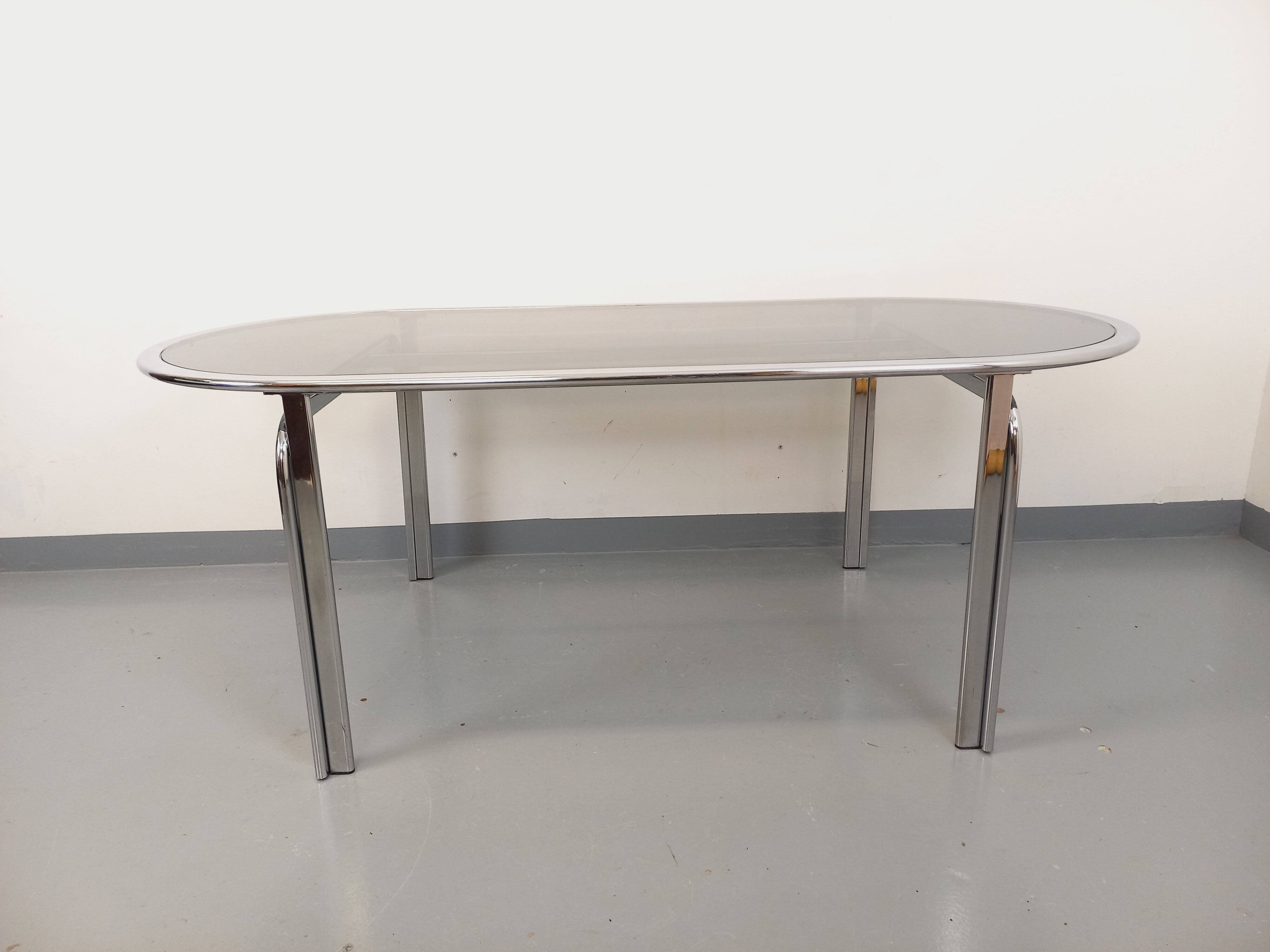 Vintage oval dining table in smoked glass and chrome metal, Space Age style.