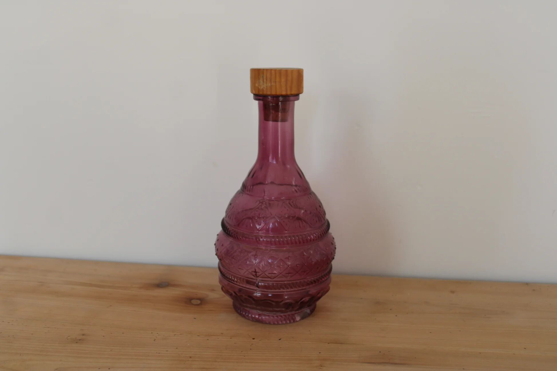 Vintage pink pressed glass carafe – retro decorative bottle with wooden stopper.