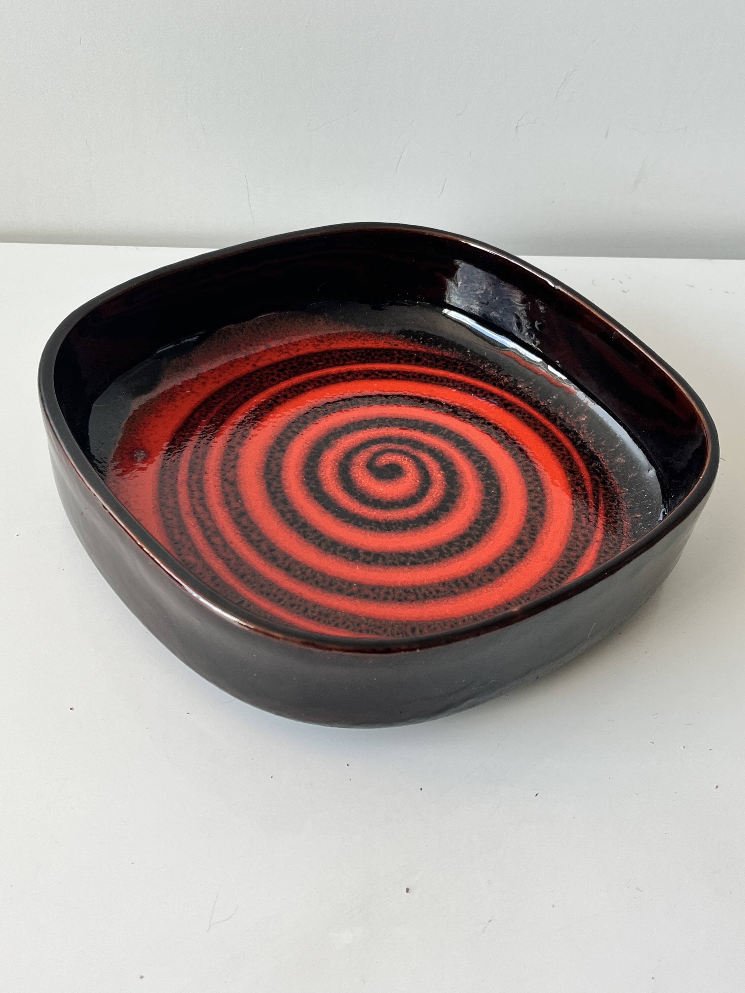 Large decorative ceramic catchall with red and black spiral pattern.