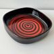 Large decorative ceramic catchall with red and black spiral pattern.