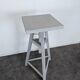 Tripod sculptor's stool in grey painted wood with a rotating top.