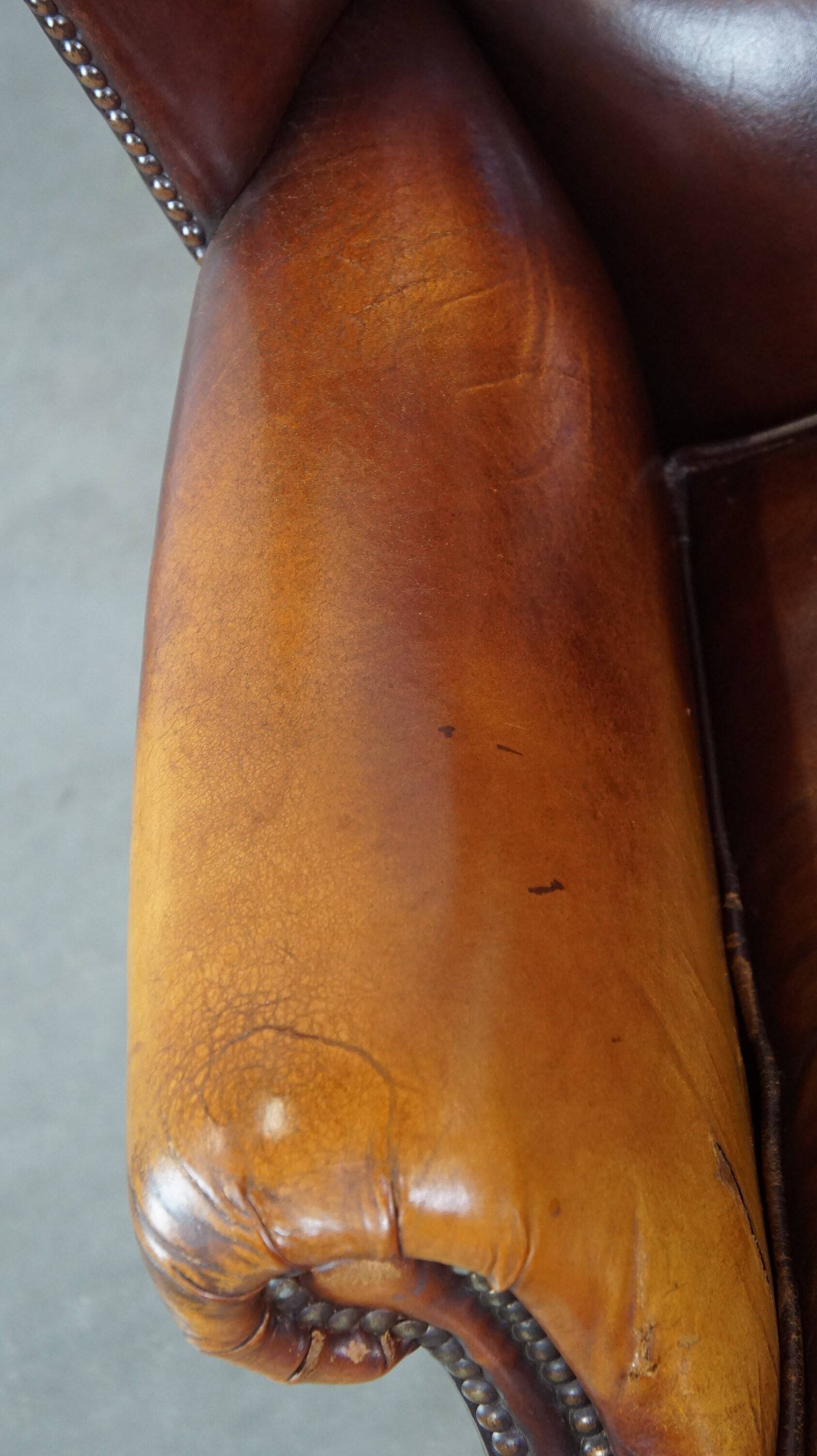 Comfortable, elegant, stately wing chair made of sheepskin in a beautiful warm color