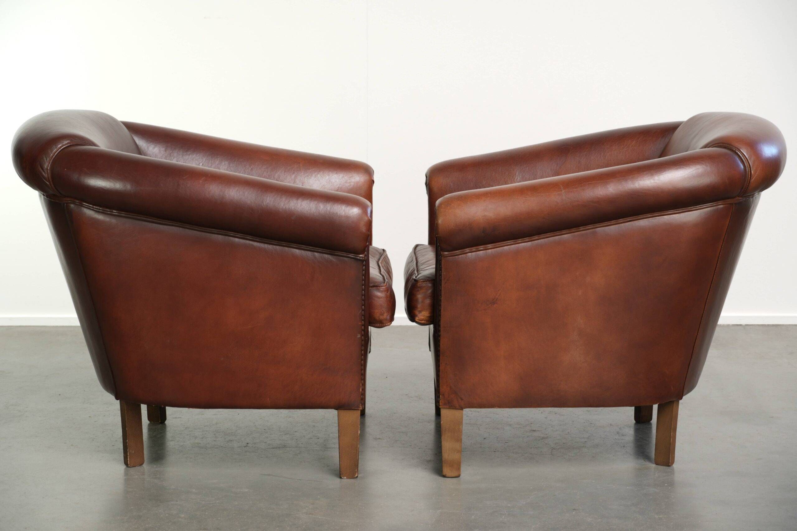 Set of 2 sheepskin club armchairs in a dark cognac colour