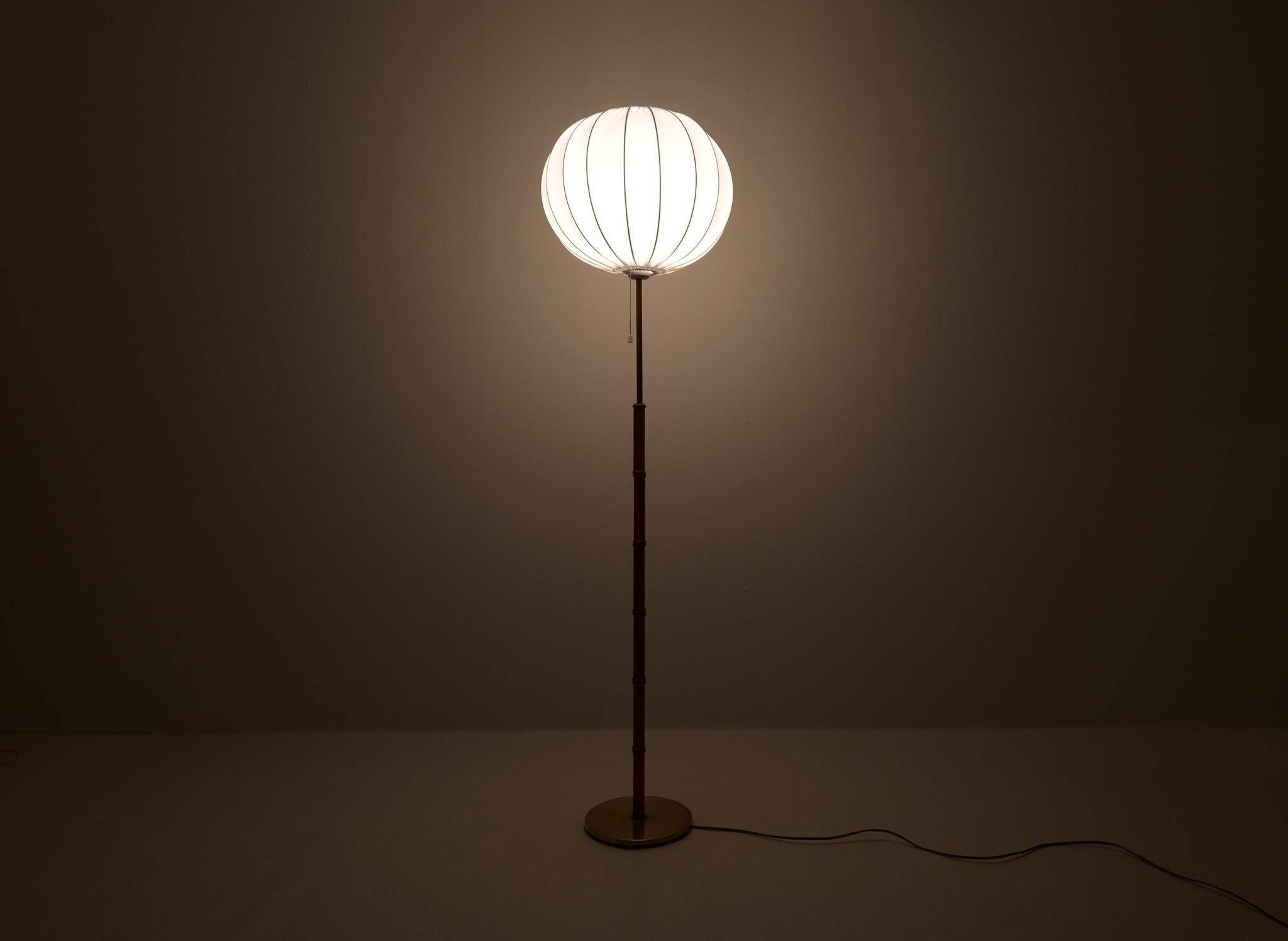 Mid-century floor lamp in brass and oak by Falkenbergs Belysning, Sweden, 1960s.