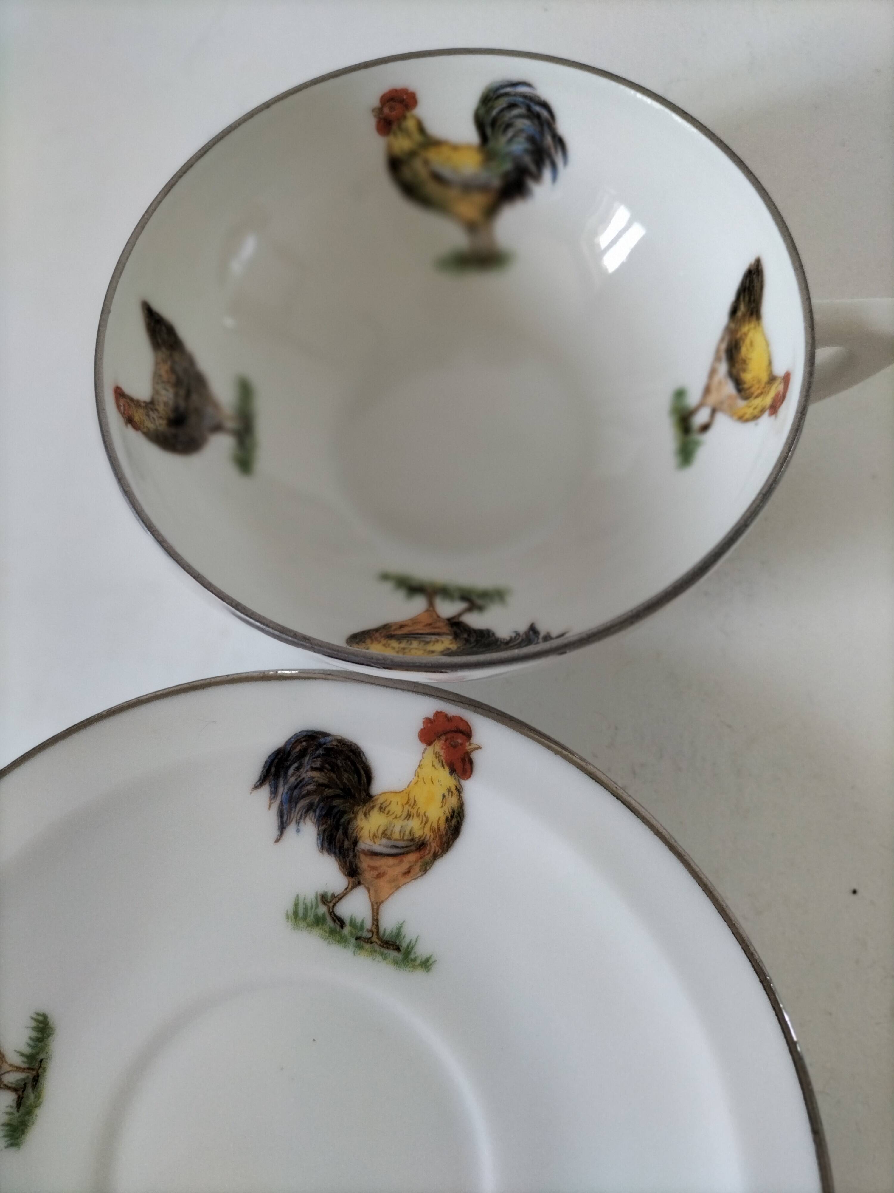 Cup and saucer in porcelain decorated with roosters and hens.