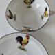 Cup and saucer in porcelain decorated with roosters and hens.