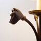 Wrought iron tripod floor lamp decorated with stylized animal heads