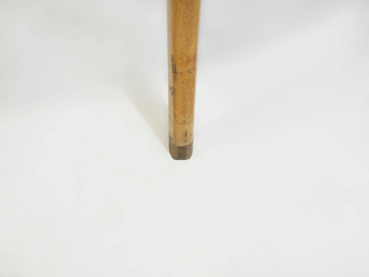 Round dining table in Wood Wood with brass details.
