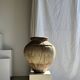Very large grey and red terracotta pot with handles and rattan crossbars.
