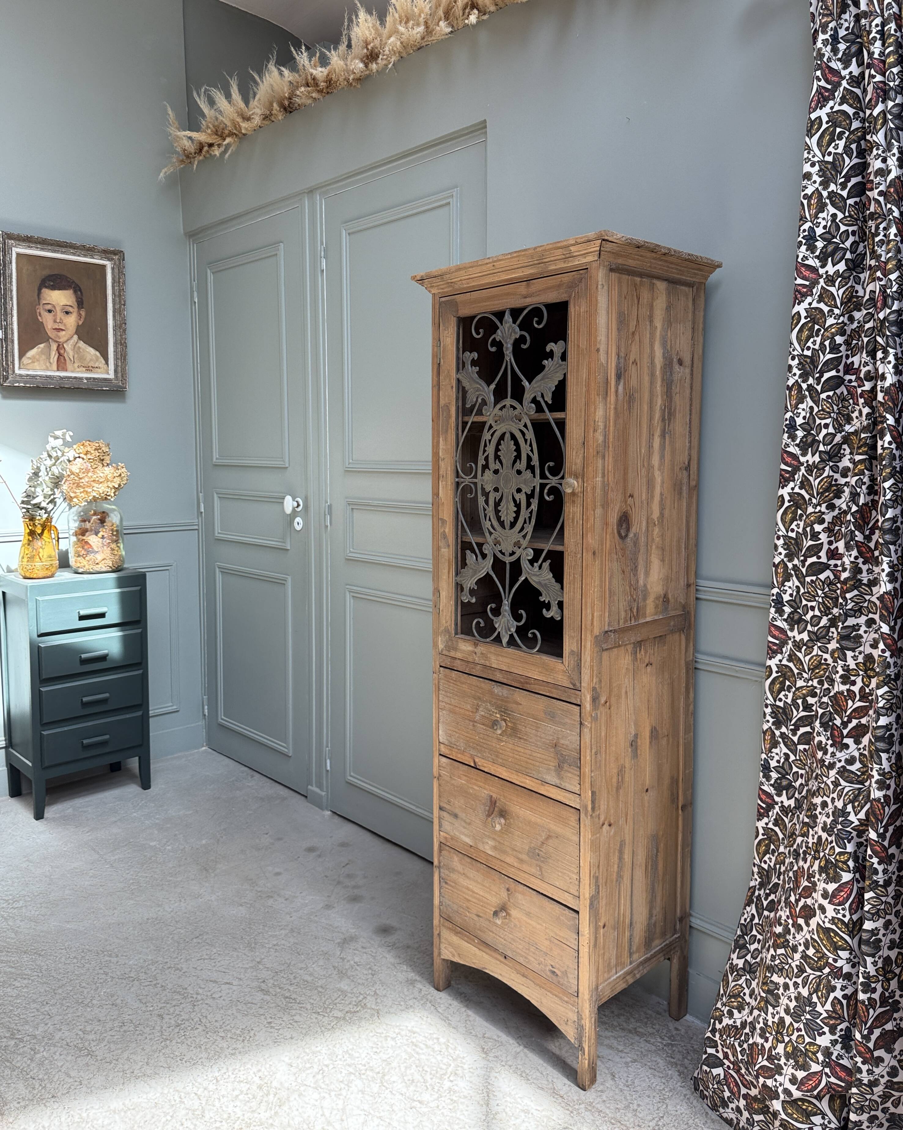 Column storage unit with a sculpted metal door.