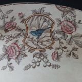 Large antique plate stamped with a fauna and flora pattern.