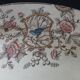 Large antique plate stamped with a fauna and flora pattern.