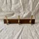Vintage wooden wall-mounted coat rack with 3 golden cast aluminum hooks