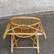 1970s adult rattan and wicker armchair with a round burgundy velvet cushion.
