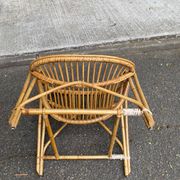 1970s adult rattan and wicker armchair with a round burgundy velvet cushion.
