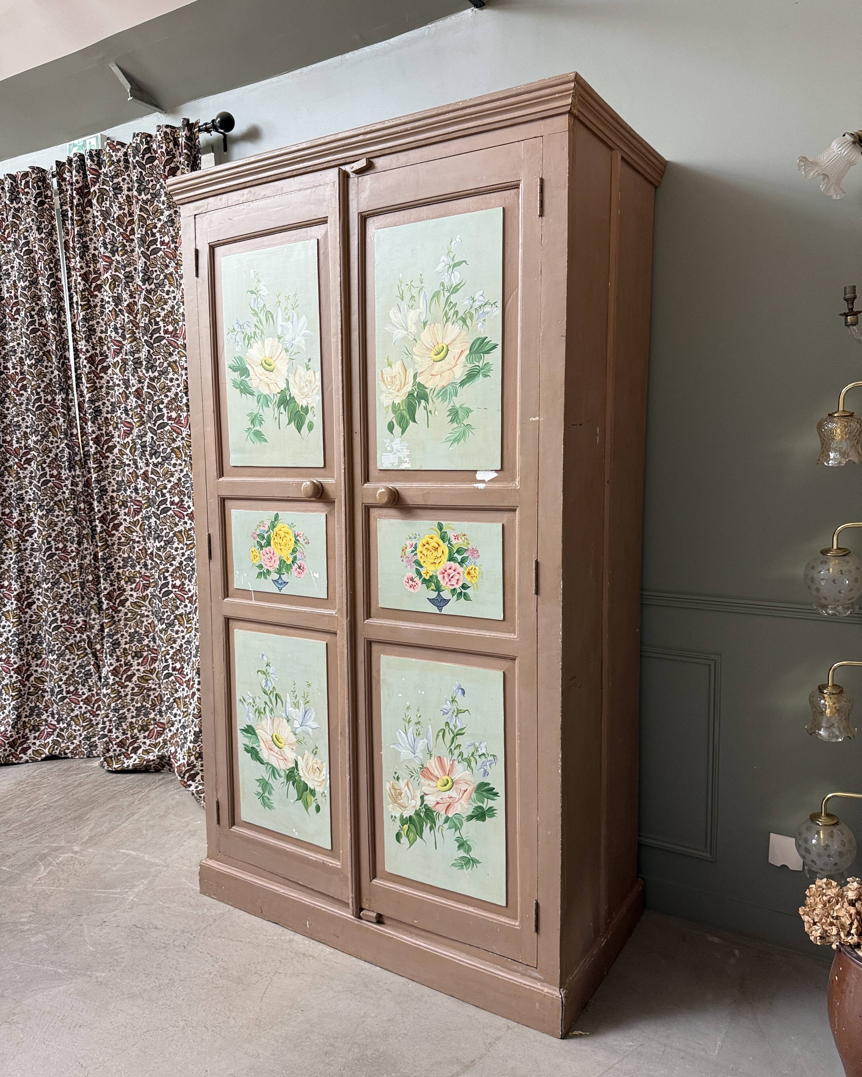 Large antique wardrobe painted with floral decoration.