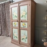Large antique wardrobe painted with floral decoration.