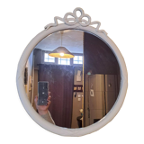 Round mirror in carved wood with at the top a ribbon forming a knot in cream color