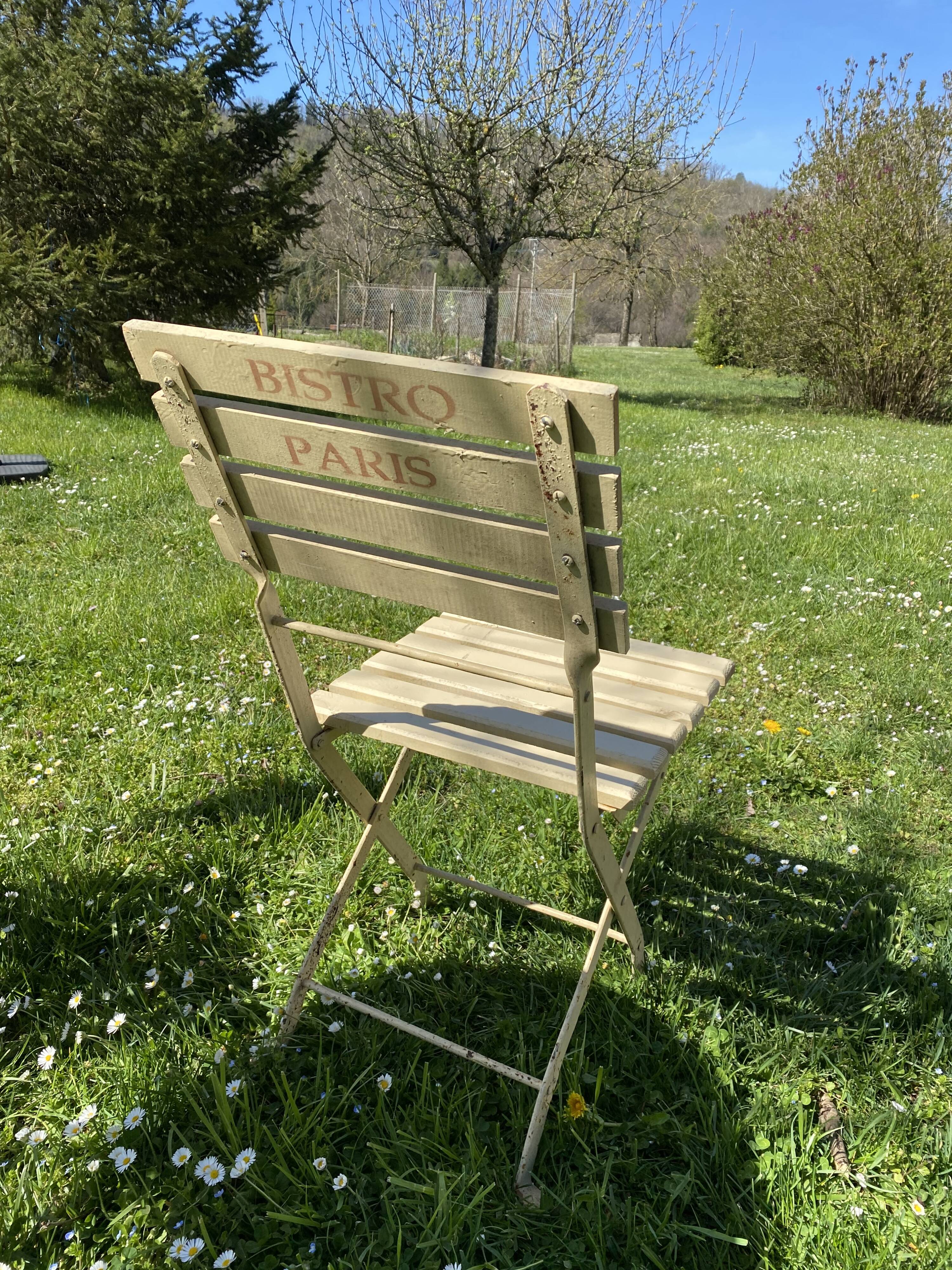 Table et 2 chaises de jardin en métal et bois beige marquées "Bistrot Paris"