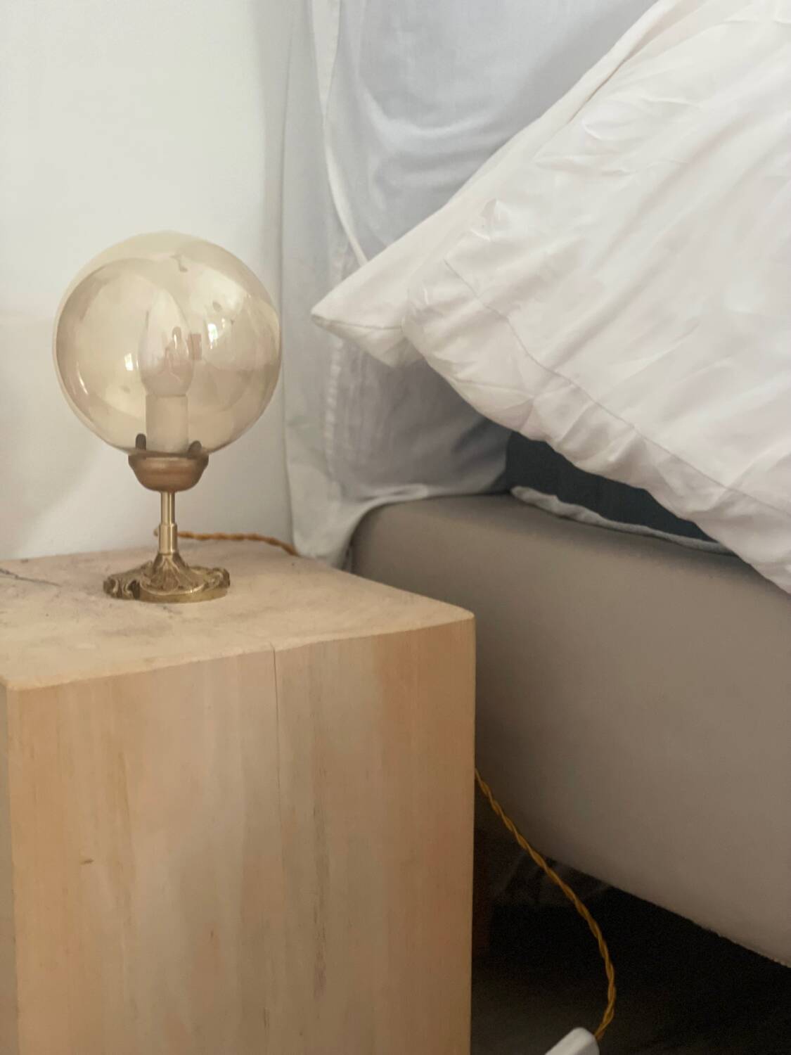 2 bedside lamps with round amber glass globes and gold metal.