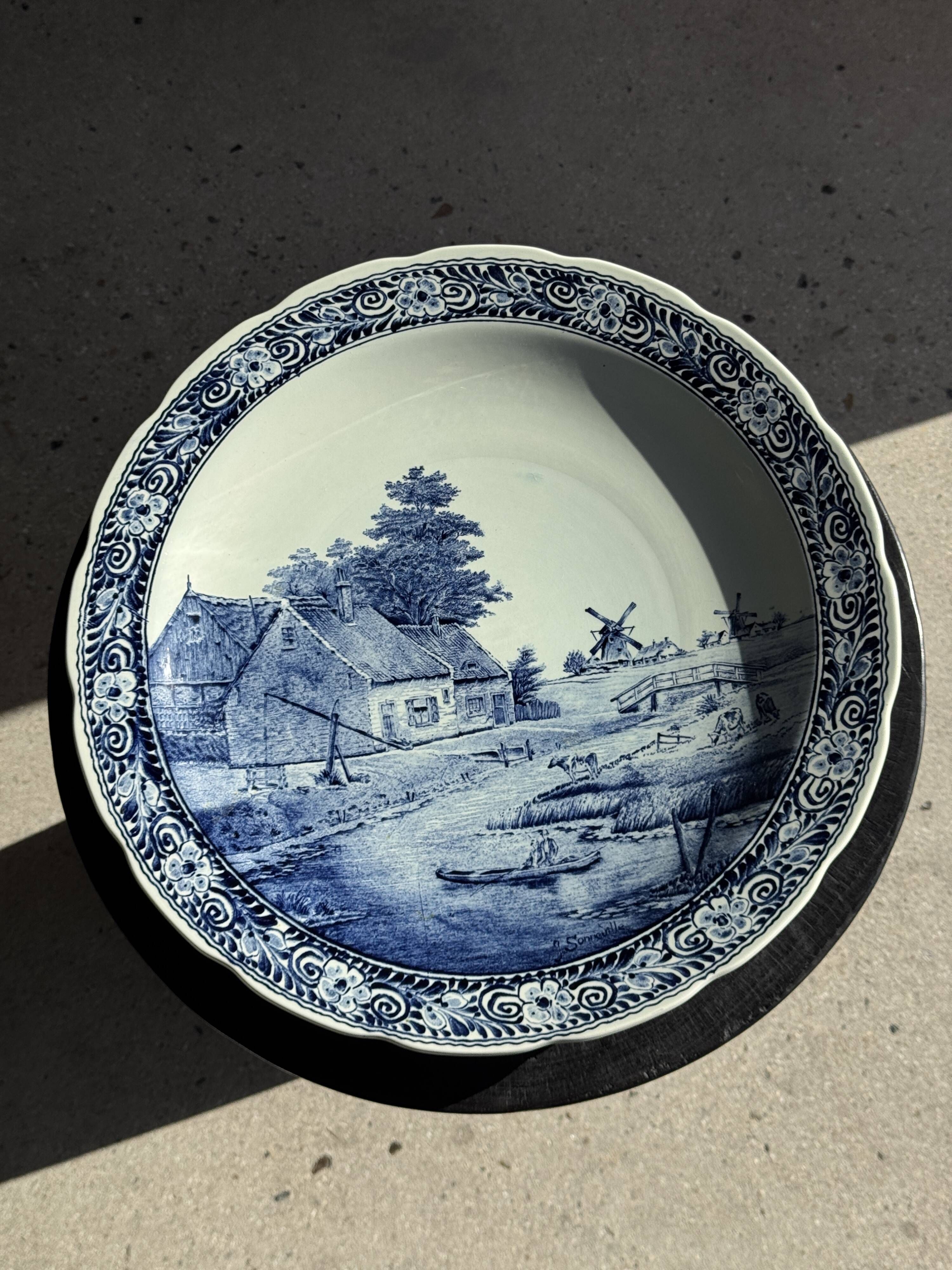 Vintage hollow circular plate in blue and white Boch pottery.