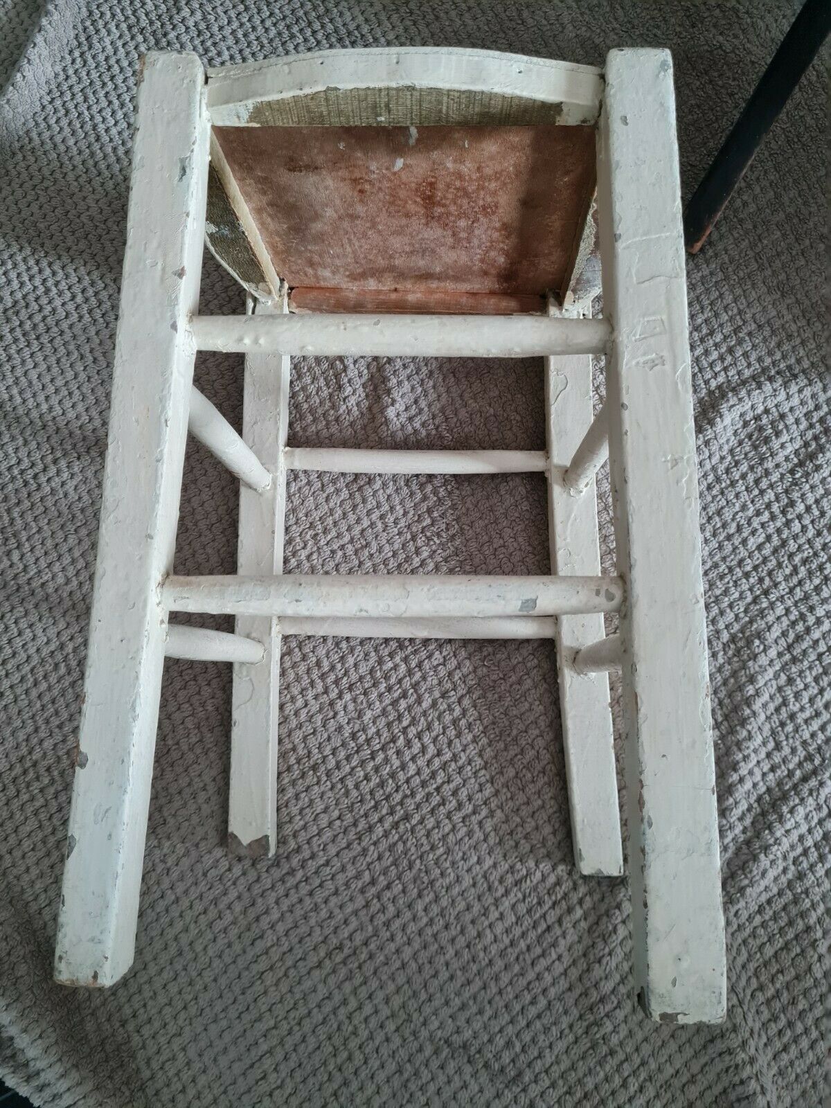 Vintage wooden stool with white peeling paint