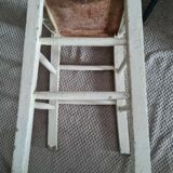 Vintage wooden stool with white peeling paint