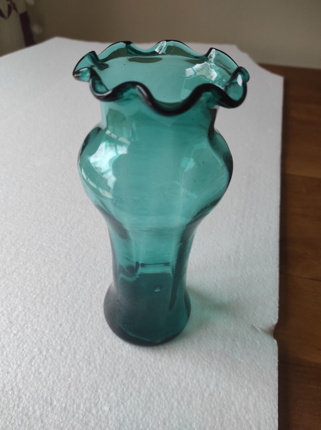 Blown glass vase with a flared neck and wavy rim.