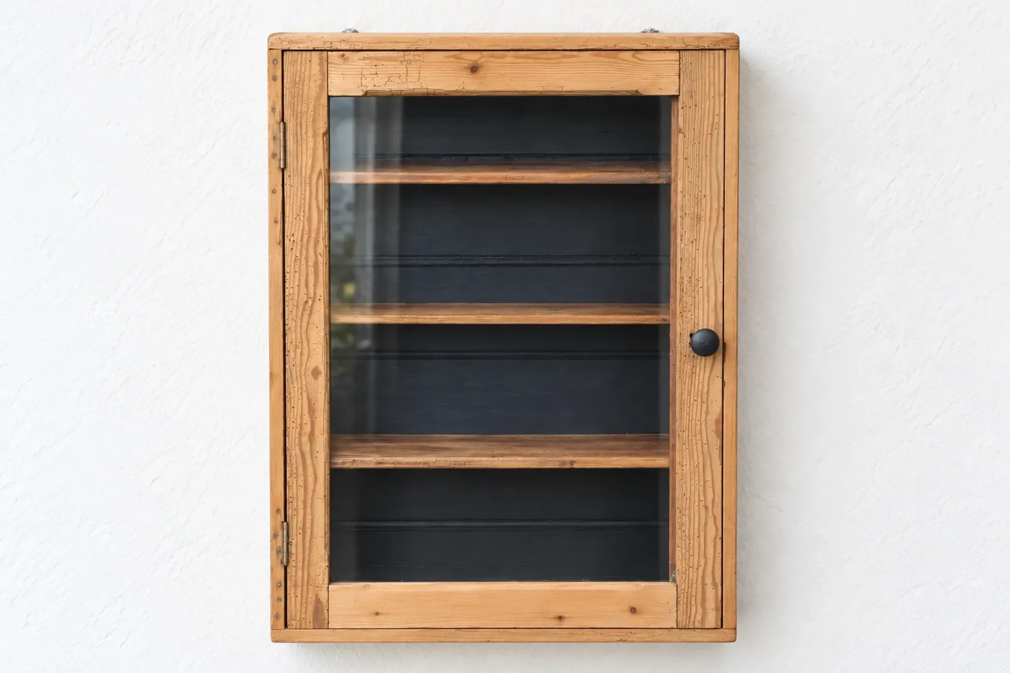 Antique wall display cabinet in natural wood and black – small glass-fronted collector's piece.