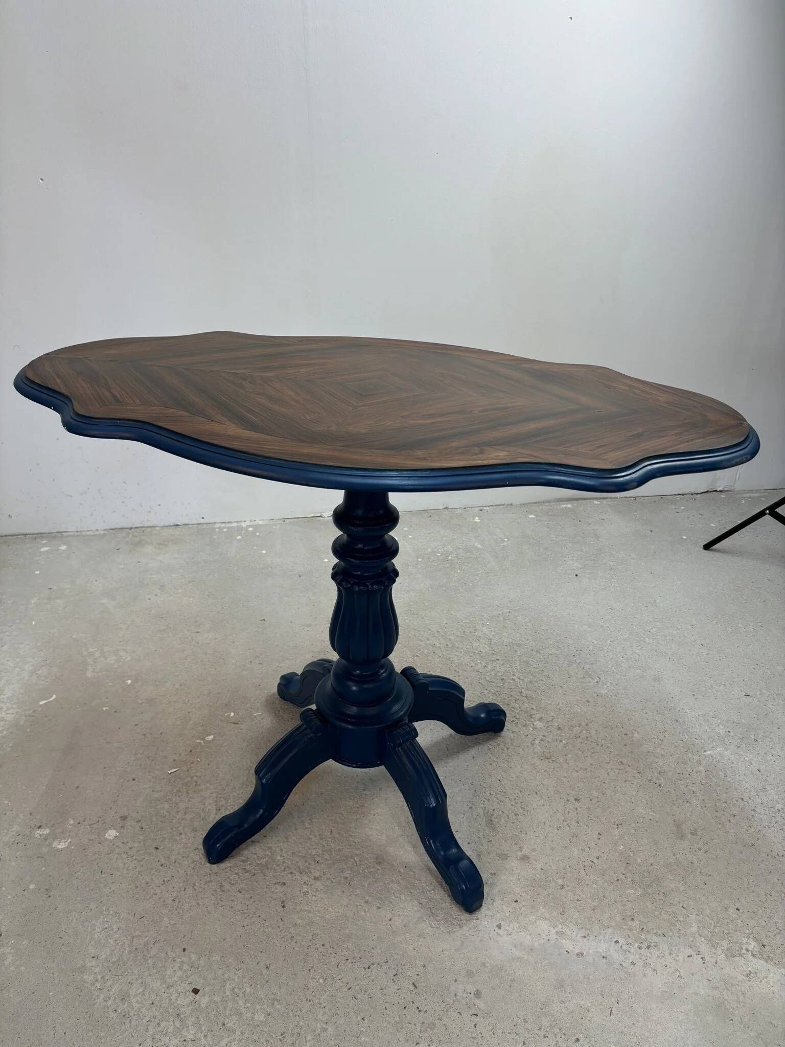 Wooden gueridon with a violin-shaped top in Rio rosewood, central base resting on four legs, reinterpreted in Baltic blue.
