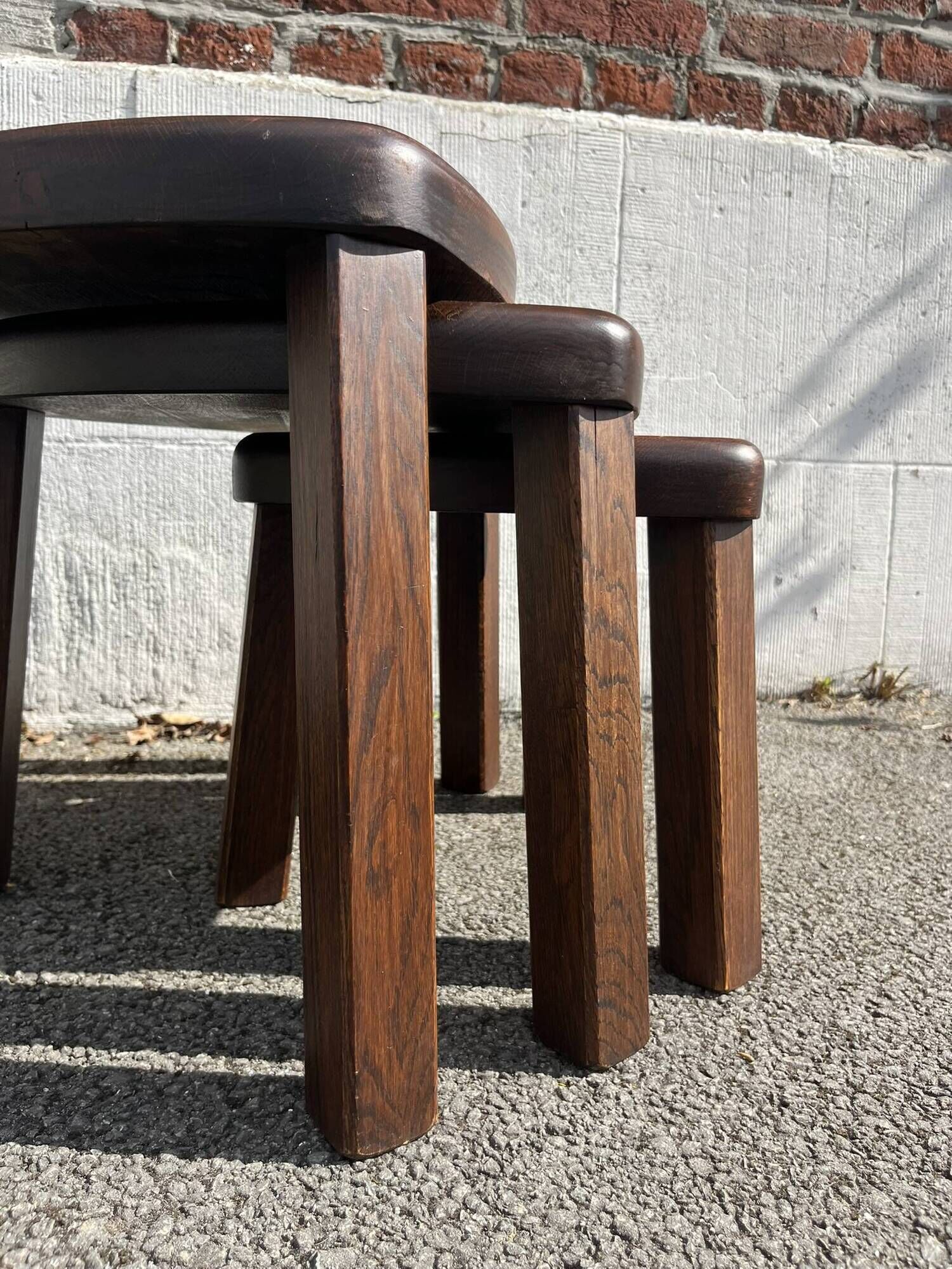 Nested tripod tables made of solid wood, in a modernist brutalist style.